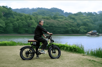 Homme roulant sur le vélo électrique fat bike OneSport W66 au bord d'un lac
