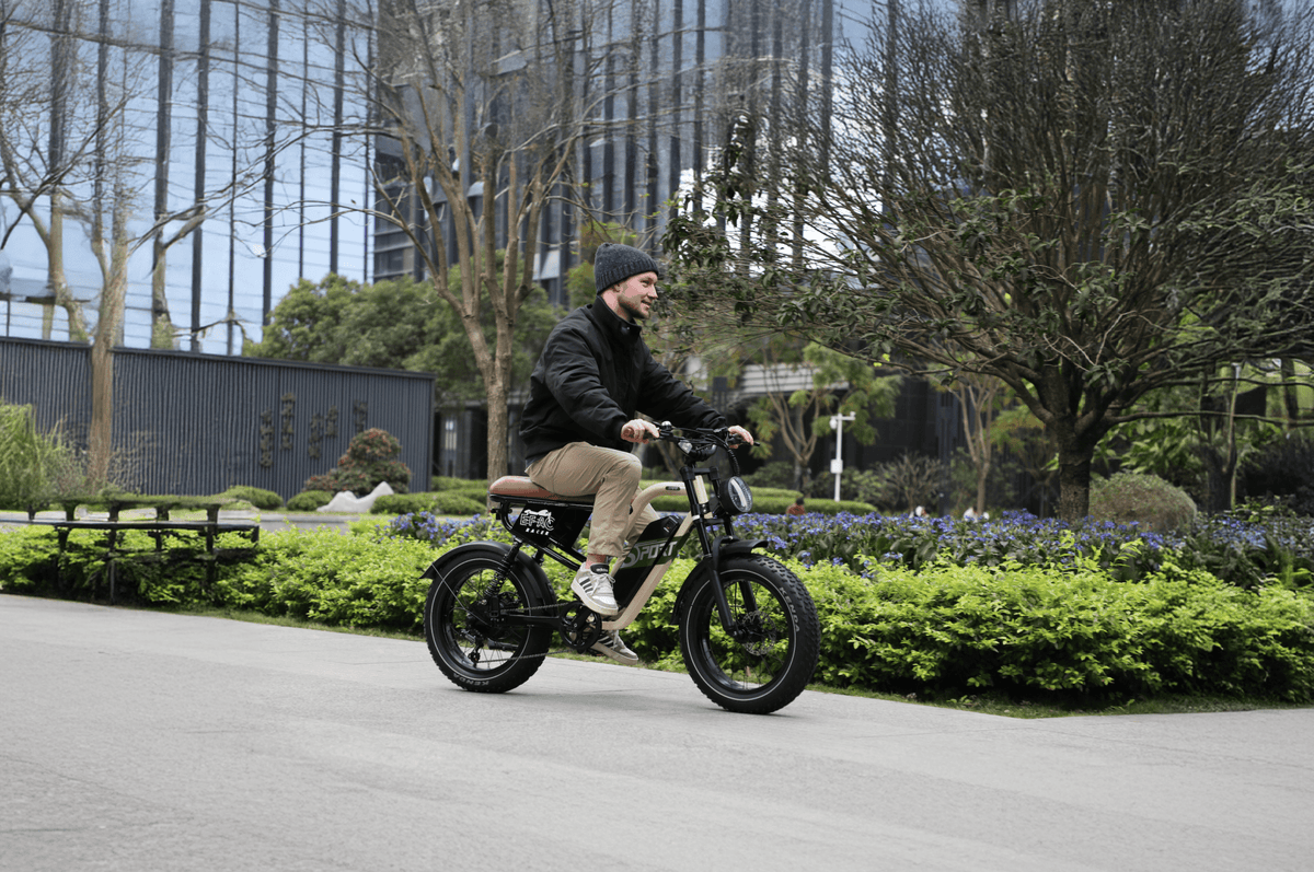 Homme roulant sur le vélo électrique fat bike OneSport W66 sur une allée