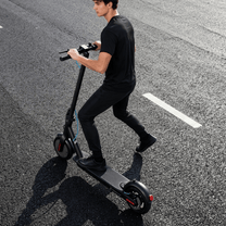 Homme roulant sur la trottinette électrique SEEDREAM RED WING MINI sur la route