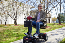 Homme assis sur le scooter de mobilité Sweetrich S1 Sport dans un parc
