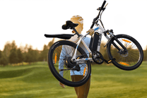 Personne debout avec le VTT électrique VARUN M24-1 coloris blanc sur une pelouse