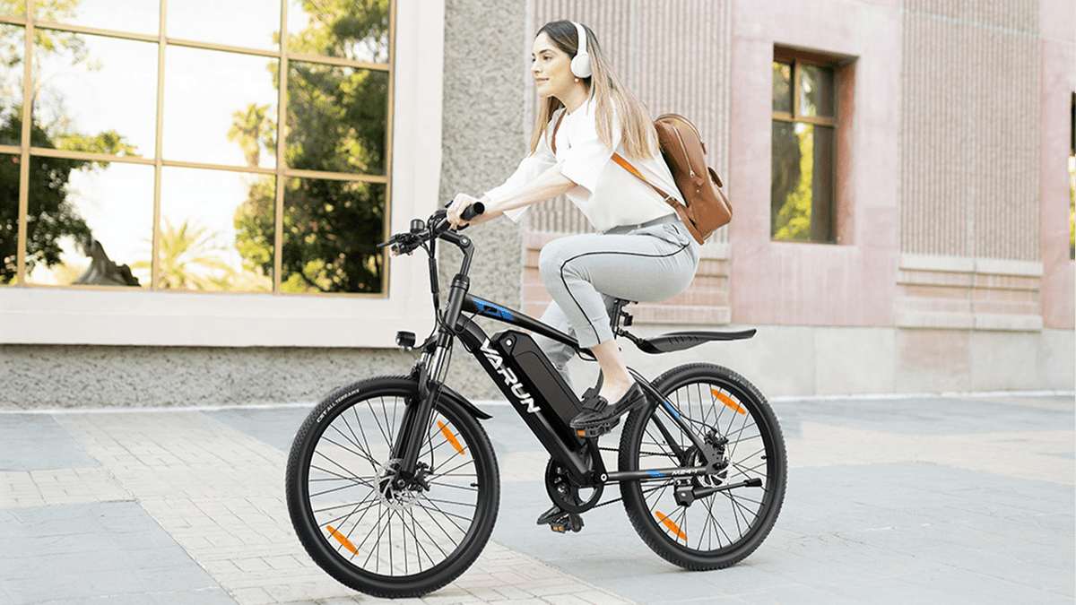 Femme roulant sur le VTT électrique VARUN M24-1 coloris noir en ville