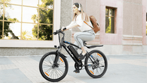 Femme roulant sur le VTT électrique VARUN M24-1 coloris noir en ville