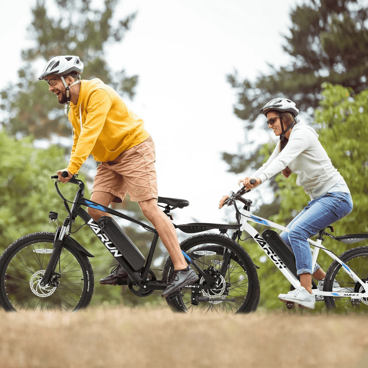 Deux personnes avec le VTT électrique VARUN M24-1 avec un casque en forêt