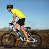 Homme roulant sur le VTT électrique VARUN M24-1 coloris blanc avec un casque sur la route