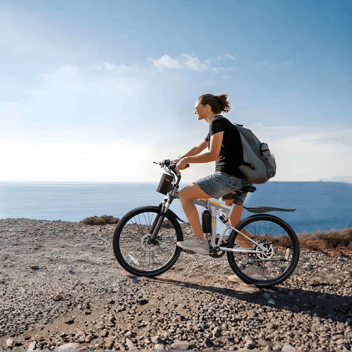 Personne roulant sur le VTT électrique VARUN M26-3 Pro coloris noir au bord de la mer
