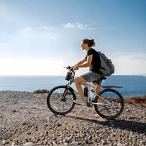 Personne roulant sur le VTT électrique VARUN M26-3 Pro coloris noir au bord de la mer