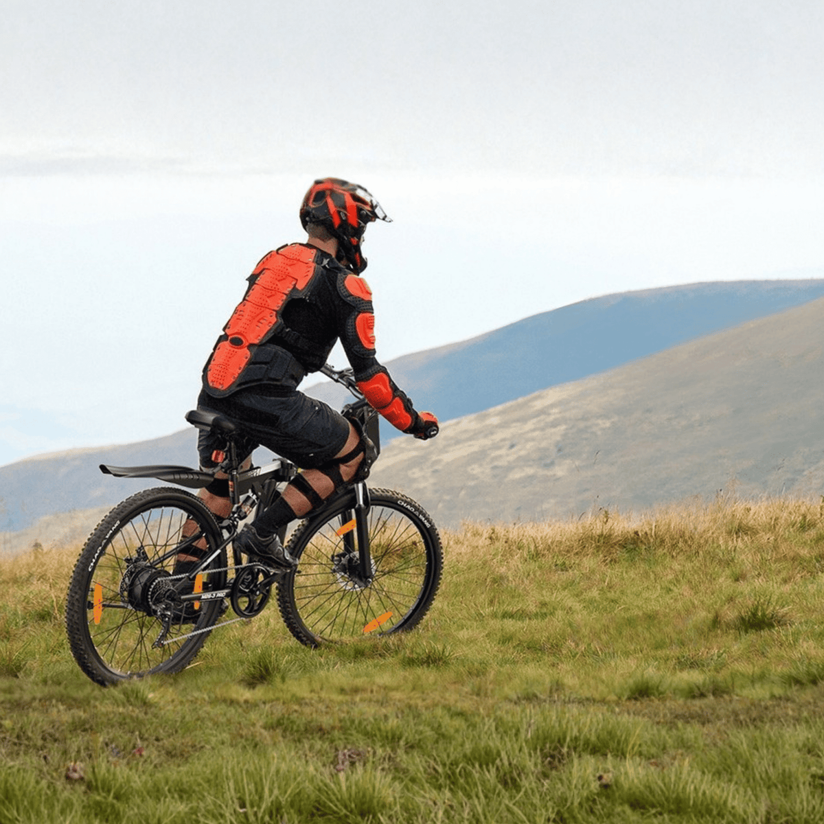 Homme roulant sur le VTT électrique VARUN M26-3 Pro coloris noir avec un casque en montagne
