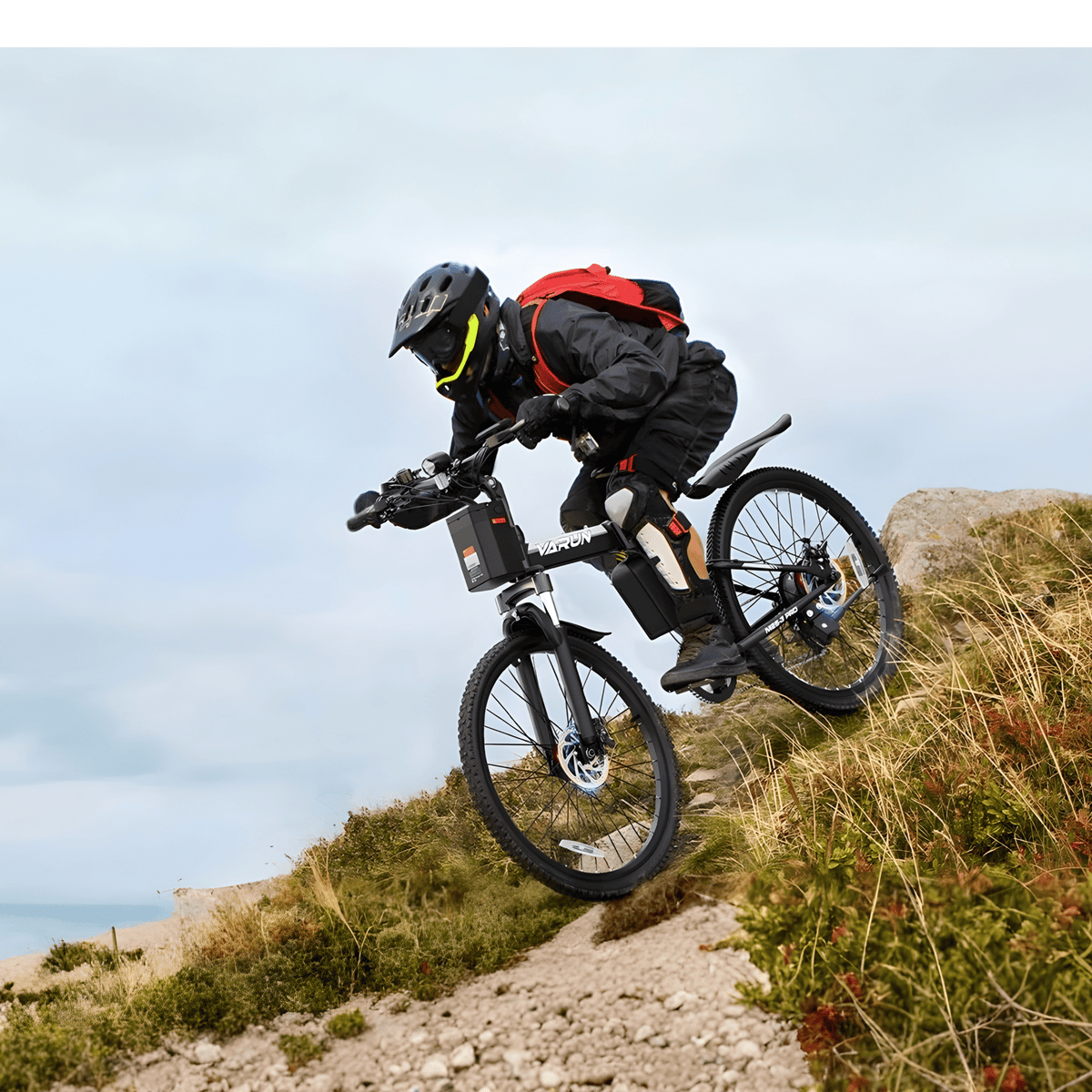 Pilote sautant avec le VTT électrique VARUN M26-3 Pro avec un casque