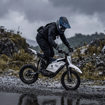 Pilote sur la moto-cross électrique Vipcoo H2 en tout-terrain sur la route