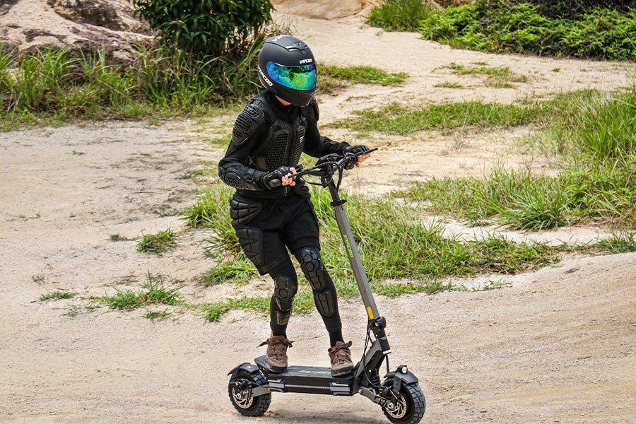 Personne roulant sur la trottinette électrique VIPCOO VS6 Pro sur un sentier