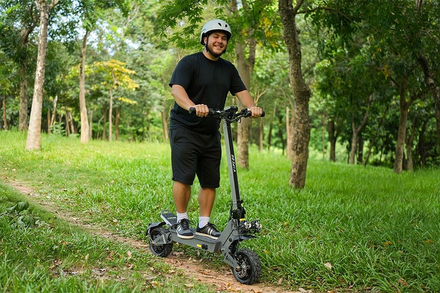 Homme debout avec la trottinette électrique VIPCOO VS9 dans un parc