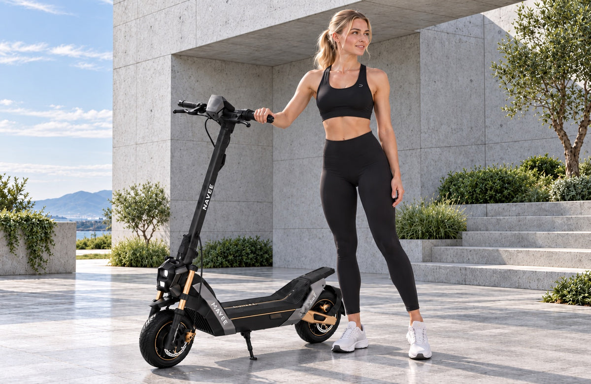 Femme avec une trottinette électrique NAVEE devant un bâtiment moderne en béton – pas de moteur à combustion, pas de gaz d’échappement, propulsion électrique